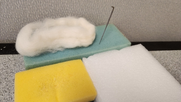 needle felting supplies such as a needle, 3 different mats, and wool roving