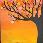 Painting of a sunset colored background with a tree and button leaves 