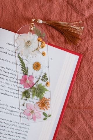 Acrylic pressed flower book mark on open book