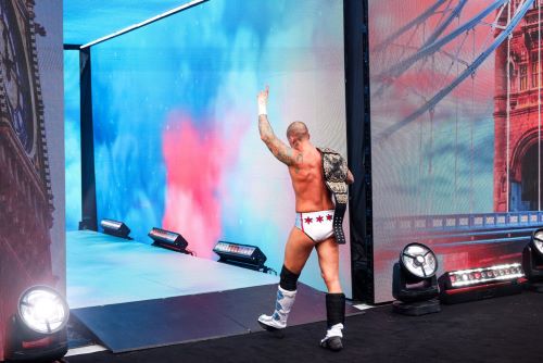 A man walks away with one arm in the air.