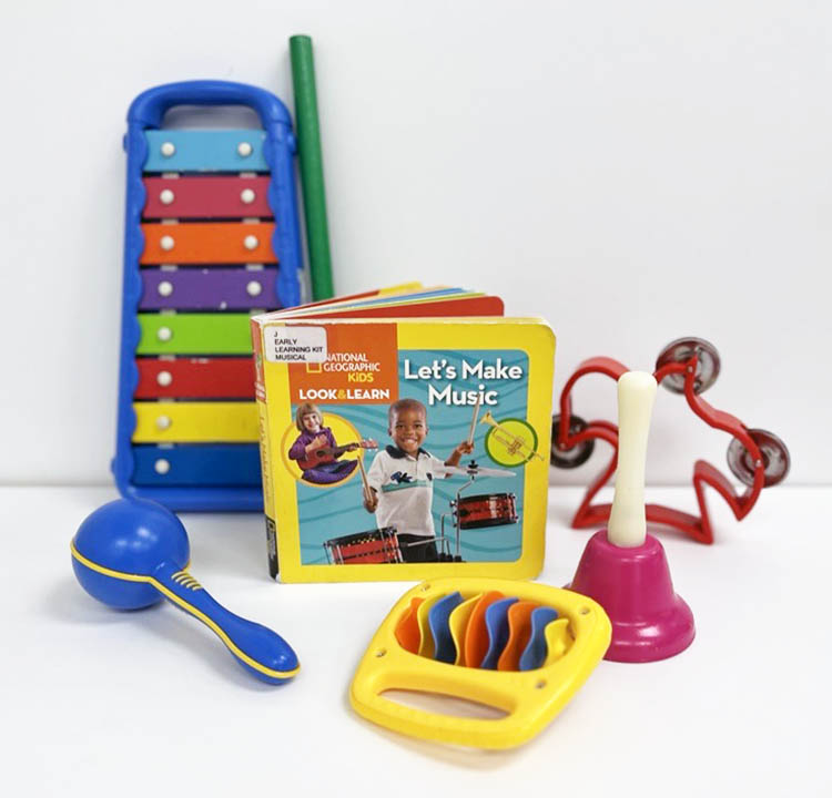 Library early learning kit with baby music book and variety of baby musical instruments that are in rainbow colors