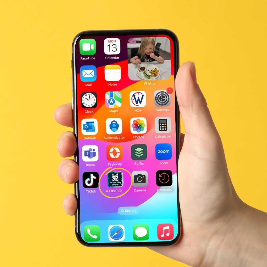 Image of a hand holding a cell phone with a yellow background