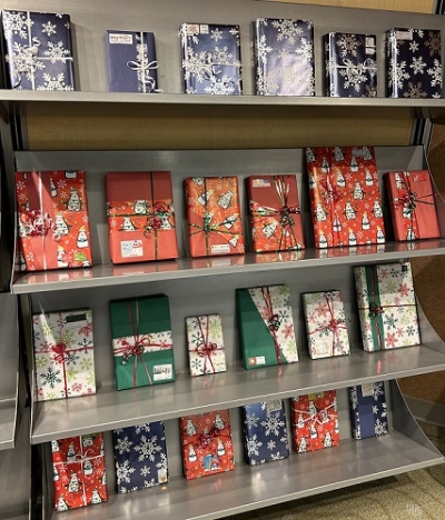 Four shelves of gift-wrapped books tied with ribbon