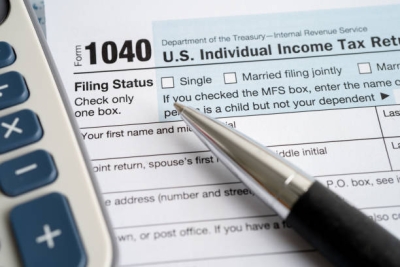 Federal 1040 tax form, pen, and calculator
