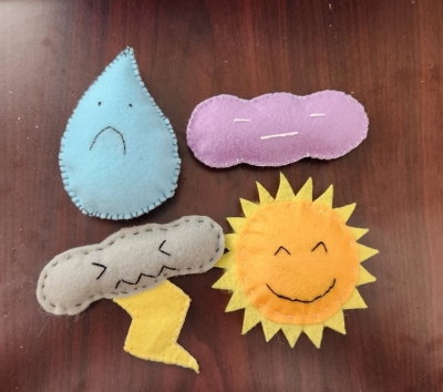 sad raindrop, content cloud, grumpy thundercloud and happy sun plushies.