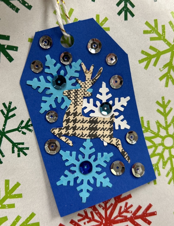blue gift tag with snowflakes and plaid reindeer