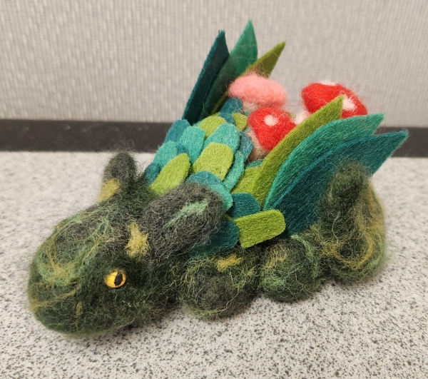 A green needle felted mushroom dragon