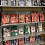 Four shelves of gift-wrapped books tied with ribbon