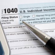 Federal 1040 tax form, pen, and calculator
