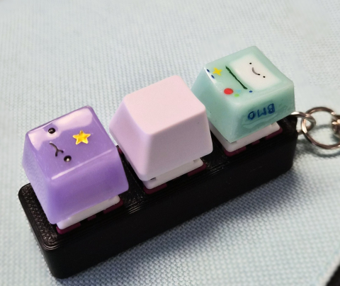 mechanical keycap fidget with two resin keycaps featuring characters from the tv show Adventure Time