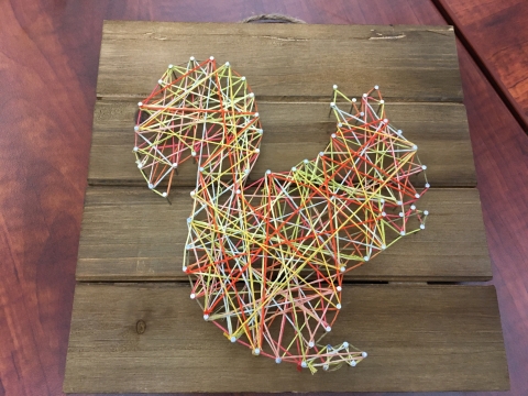 Squirrel silhouette string art on wood board