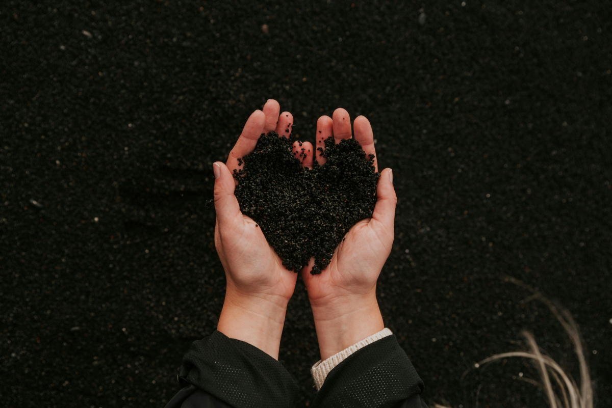 hands cupping gardening soil in the shape of a heart